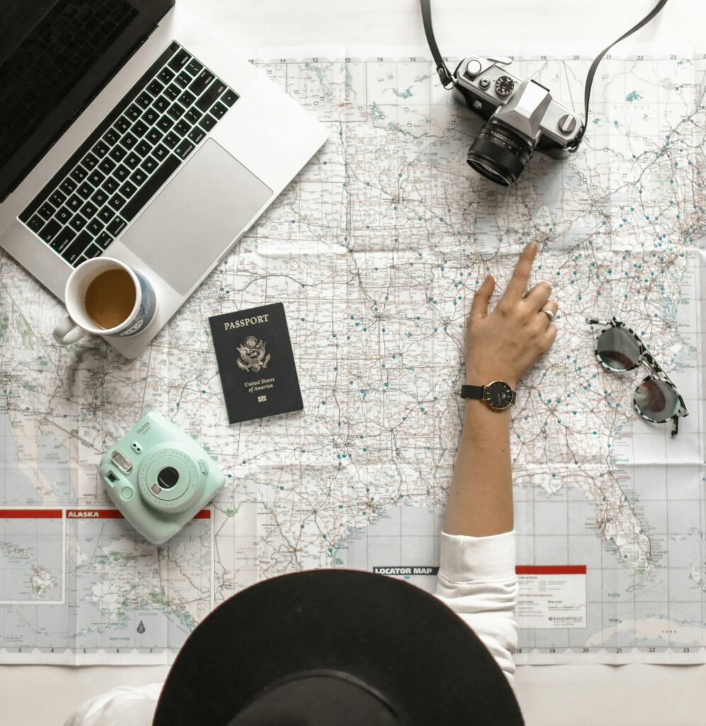 pexels-photo-1051075-1051075 Hand on map with camera, passport, laptop, and coffee, perfect for travel planning inspiration.